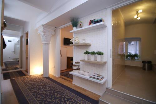 萨拉热窝Guesthouse Kod Keme的走廊上设有白色墙壁和植物架子