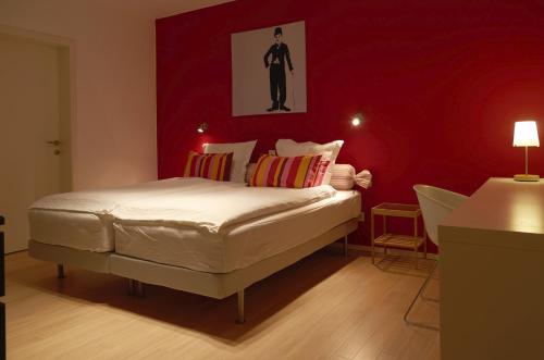 鲁汶Nena Guesthouse的卧室配有白色的床铺和红色的墙壁