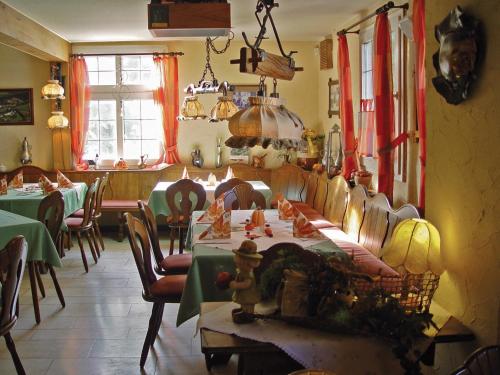 古梅尔斯巴赫莱因霍尔德酒店的用餐室配有桌椅和桌椅