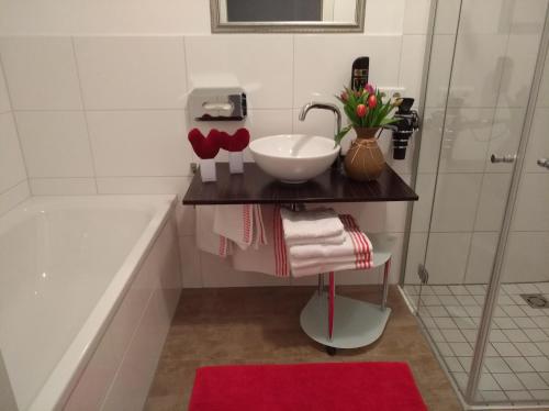 蒙德塞Erlachmühle的浴室配有盥洗盆和浴缸。