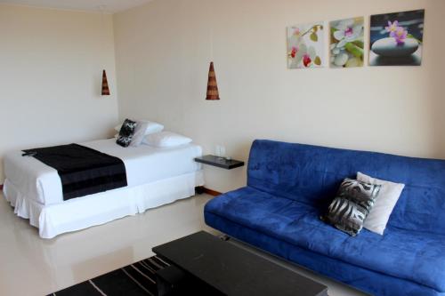 拉帕洛马泽恩精品公寓酒店的客厅配有蓝色的沙发和床。