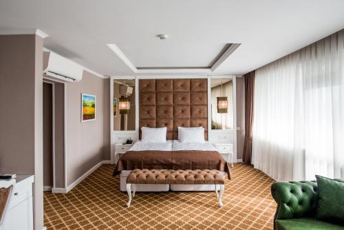 克尔贾利阿佩佐斯酒店的一间卧室配有一张大床和一张绿色沙发