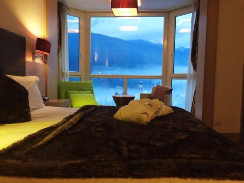博尔查迪卡多尔安特劳多洛米蒂山度假酒店的一间卧室设有一张大床和大窗户