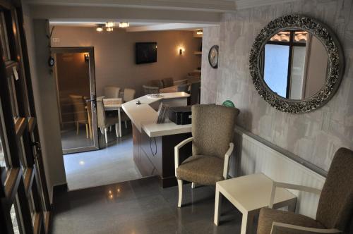 普里什蒂纳普瑞玛酒店的一间设有镜子和桌椅的房间