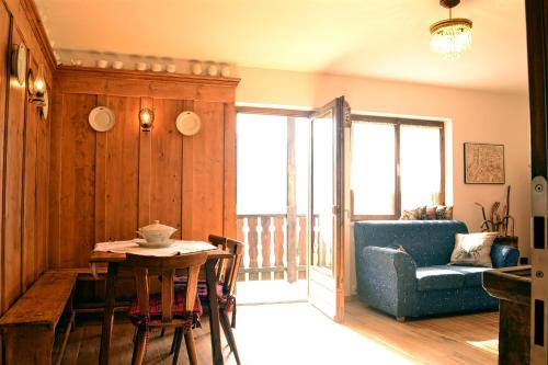 卡拉诺Casa del Salice的客厅配有桌子、蓝色沙发和椅子
