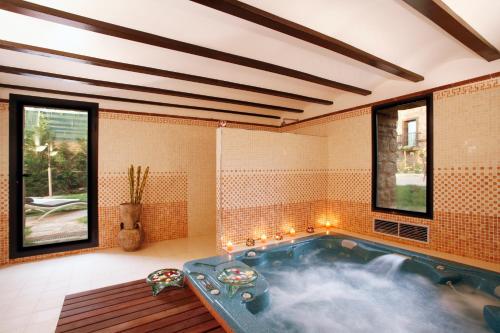 Azofra卡索纳德拉萨马斯真实度假酒店的带窗户的客房内的按摩浴缸