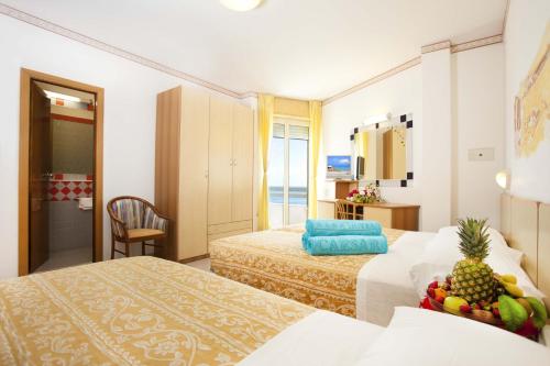 切塞纳蒂科凯撒酒店的酒店客房,设有两张床,上面有水果