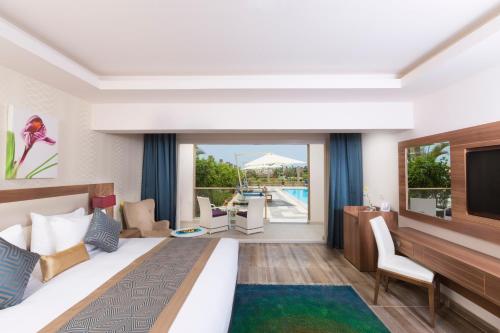 沙姆沙伊赫Pickalbatros Aqua Blu Sharm El Sheikh的酒店客房设有一张大床和一台电视。