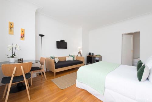 拉罗谢尔Villa Verde La Rochelle的一间卧室配有一张床、一张桌子和一张沙发