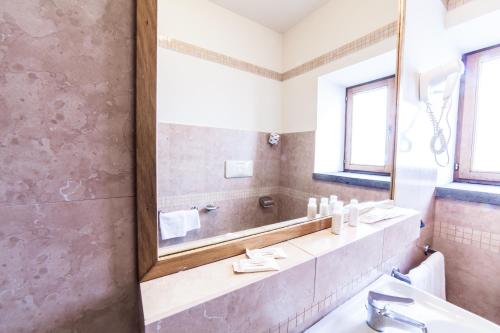 尼科洛西智慧酒店的一间带大镜子和盥洗盆的浴室