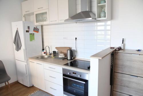 贝尔格莱德Bardolino Apartment的小厨房配有白色橱柜和冰箱。