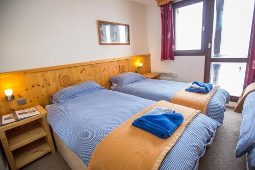 瓦尔梅尼耶莱吉尔酒店的两张位于酒店客房的床,上面有蓝色的毛巾