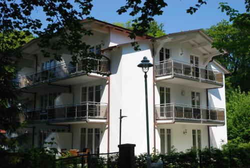 奥斯赛拜-塞林Strandwohnungen Sellin - WG02 mit Terrasse的带阳台的白色建筑和街灯