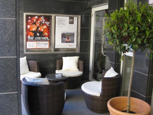 林茨冬穆酒店的一间设有藤椅和盆栽的房间