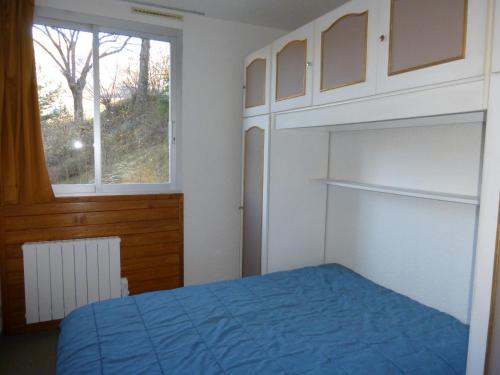 勒索兹GRANDE CHAUME A 42的一间卧室设有蓝色的床和窗户。