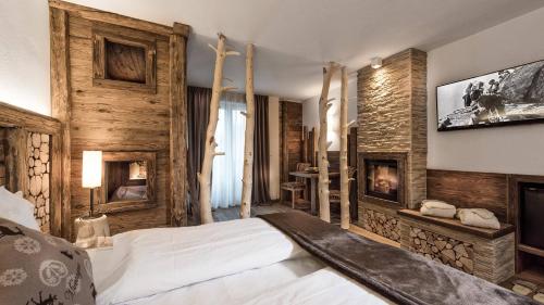 摩德纳迪-坎皮格里奥浪漫广场体育酒店的一间卧室配有一张床和一个壁炉