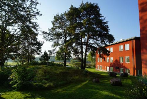 奥克什贝里亚鲁诺莫顿与活动酒店的一座橘色的建筑,位于绿树旁的草木小山上