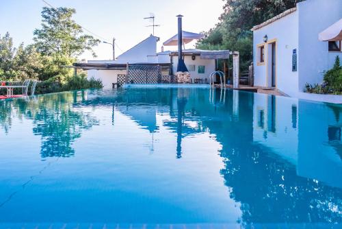 SalirCasa da Tita的一座房子前面的蓝色海水游泳池