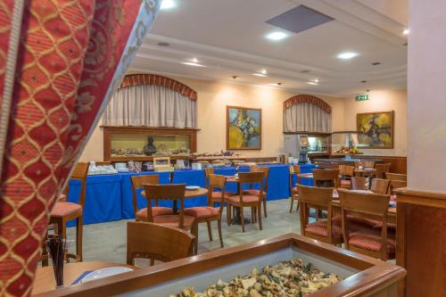 奇维塔韦基亚特拉亚诺酒店的餐厅内带桌椅的用餐室