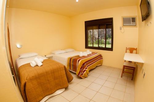 CristalPousada Pedra Bonita的酒店客房设有两张床和窗户。