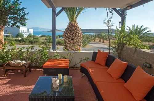 Diakofti迈斯特拉里公寓酒店的庭院配有橙色沙发和玻璃桌。