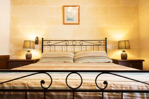 斯利马Maltese Town House Sliema的卧室内的一张床位,配有两张台灯
