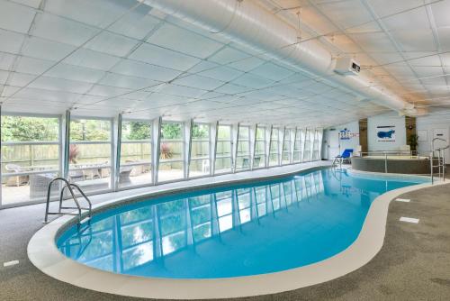 赫克瑟姆George Hotel的大型室内游泳池,拥有蓝色的海水和窗户