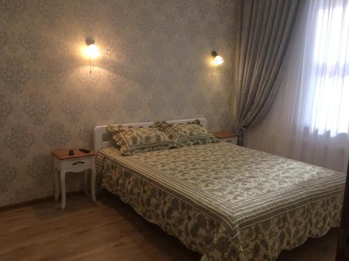 克里扎尼夫卡Morskaya zhemchuzhina na Marselskoy的卧室配有一张床,墙上有两盏灯