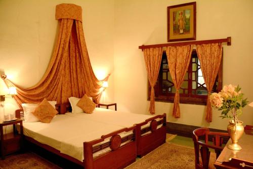 KarauliBhanwar Vilas Palace的一间卧室设有一张床和两个窗户。