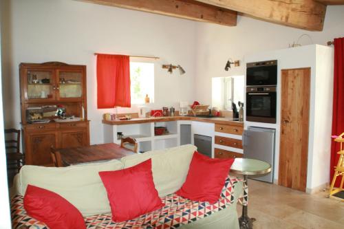 Le CrosMas des Clauzals的厨房配有白色沙发和红色枕头