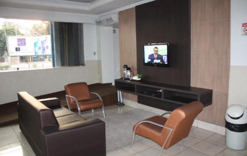Hotel Express - Leva e busca no aeroporto grátis 24 horas的电视和/或娱乐中心