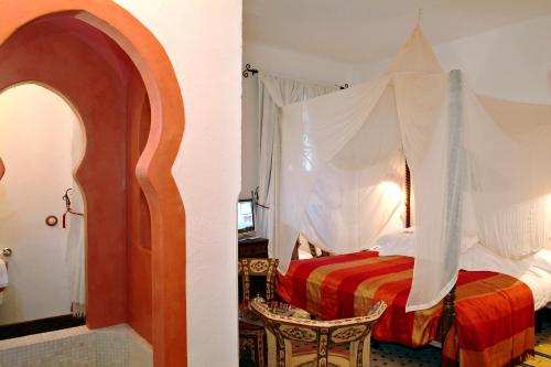 塞维利亚塞维利亚国王寝宫酒店的一间卧室配有一张带天蓬的床