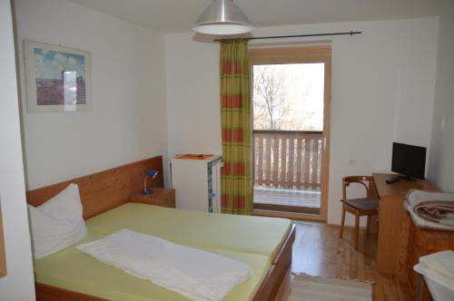 Sankt Paul im LavanttalGasthof Johannesmesner的一间卧室配有一张床、一张书桌和一个窗户。