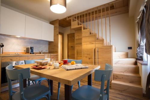 尚波吕克Maison Fosson的厨房以及带木桌和椅子的用餐室。
