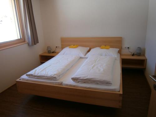 布雷根茨沃尔德地区奥Haus Zitterklapfen的一间卧室设有两张带白色床单的床和窗户。