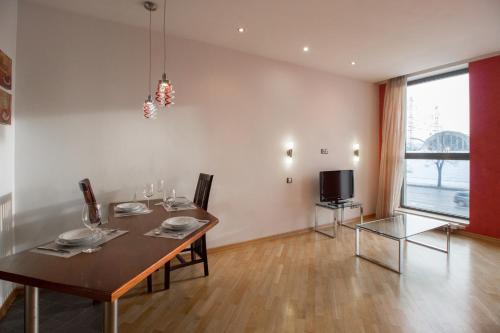 里加Riga City Center Apartment的一间带桌子和电视的用餐室