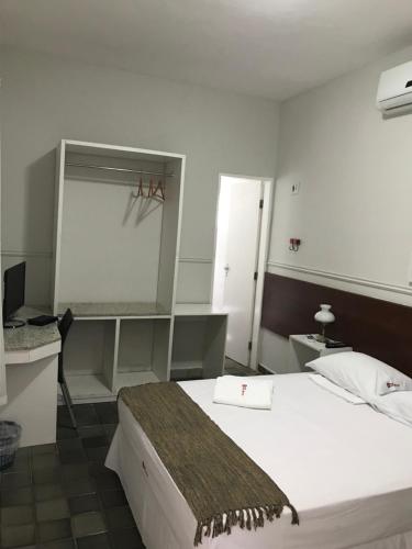 特雷西纳韦柳蒙赫酒店的一间卧室配有一张床、一张书桌和一面镜子