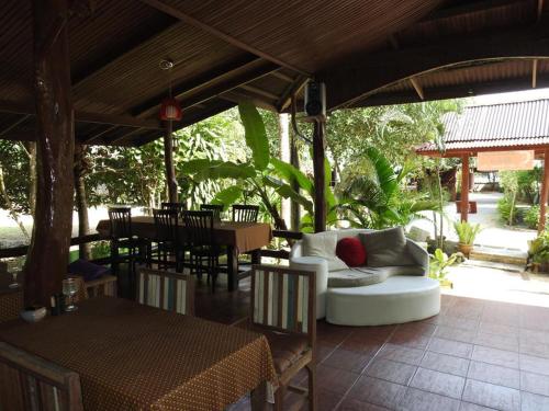 通奈潘海滩布达拉克撒旅馆的庭院配有白色的沙发、桌子和椅子