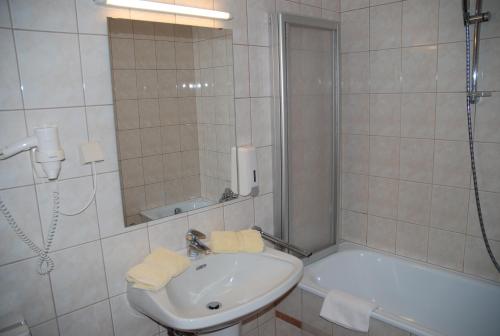 特雷芬Hotel Kuchlerwirt的浴室配有水槽、淋浴和浴缸。