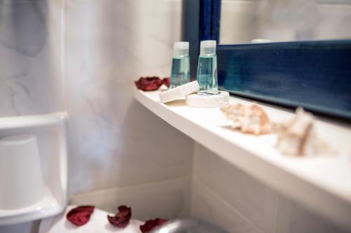 Diakofti迈斯特拉里公寓酒店的一间带水槽的浴室,地板上有些玫瑰花