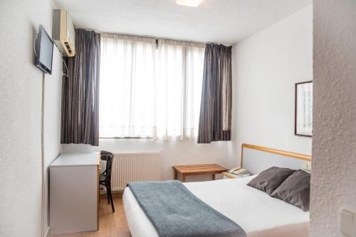 索托德尔雷亚尔普拉多酒店的配有一张床、一张书桌和一扇窗户的酒店客房