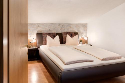 奥布施泰希Appartementhaus Bergland的卧室配有一张带白色床单和枕头的大床。
