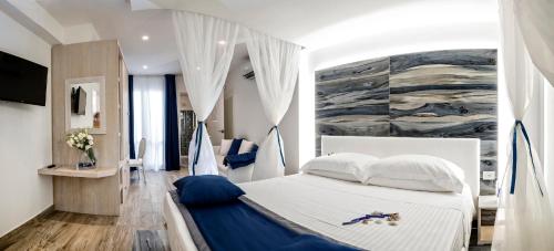 圣维托罗卡波Il Mare Dentro Rooms的卧室配有一张白色床,墙上挂有绘画作品