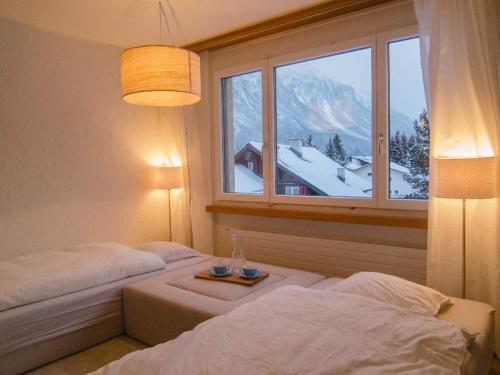伦策海德Seestrasse 1 (292Ap)的一间卧室设有一张床和一个白雪 ⁇ 的窗户