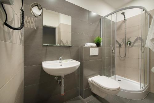 布拉格科特布斯酒店的一间带水槽、卫生间和淋浴的浴室