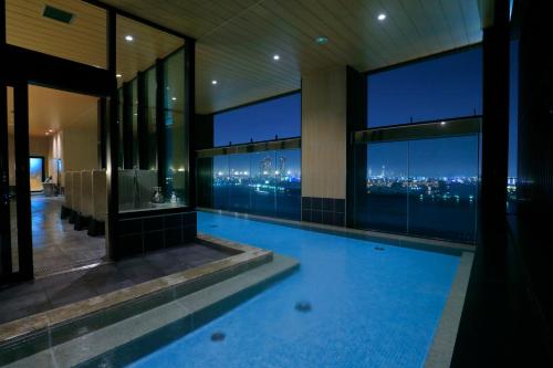 大阪THE SINGULARI HOTEL & SKYSPA at UNIVERSAL STUDIOS JAPAN的一座游泳池,位于一座享有城市美景的建筑内