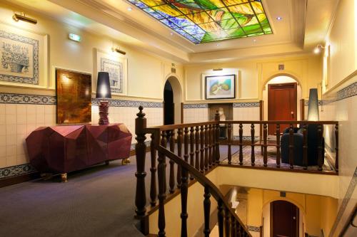 波尔图波尔图国际港务酒店的走廊上设有彩色玻璃天花板的楼梯