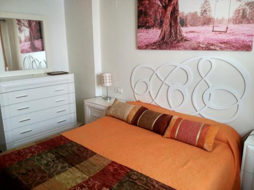 滨海罗克塔斯Salinas Comfort的一间卧室配有一张带橙色毯子的大床