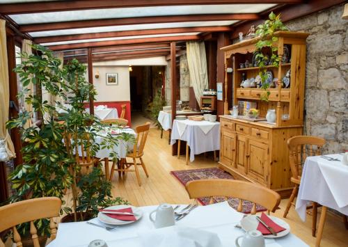 邓弗姆林Clarke Cottage Guest House的一间在房间内配有桌椅的餐厅