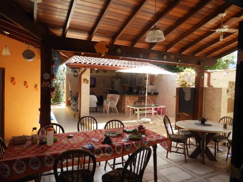 卡拉瓜塔图巴ACIOLY'S BEACH HOUSE的庭院配有桌椅和遮阳伞。